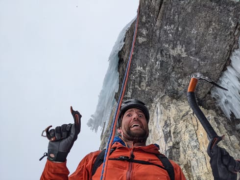 An ice climber showcases the broken handle of an ice tool. It's snapped where the rubber handle meets the aluminum shaft.